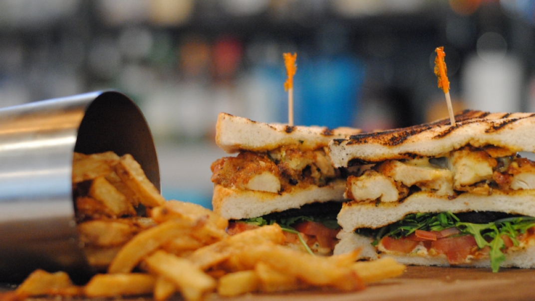 a toasted sandwich with fries and a silver fry cup