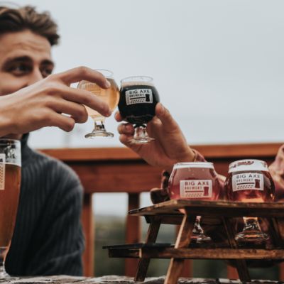 two men holding beers and toasting